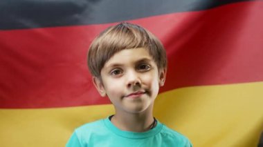 Almanya Ulusal Bayrağı Altında Mutlu Alman Küçük Vatansever Çocuk. Demokrasinin, bağımsızlığın, AB 'nin geleceğinin sembolü. afiş, çocuk günü, seçim, Avrupa, futbol.