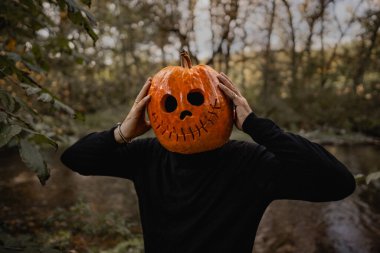 Cadılar Bayramı için balkabağı kafalı korkunç bir adam. Balkabağı kostümü. Şeker mi şaka mı? Çerçevenin ortasına portakal kabağı. Yüksek kalite fotoğraf