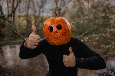 Cadılar Bayramı için balkabağı kafalı, olumlu gülümseyen bir adam, jest gibi. Balkabağı kostümü. Şeker mi şaka mı? Yüksek kalite fotoğraf