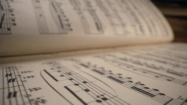 Kaydedilmiş ortaçağ müzik kitaplarının kaypak makro arkaplanı ve antik notalar. Eski klasik senfoninin dokusu, güzel melodi, hobi konsepti. Yüksek kalite 4k görüntü