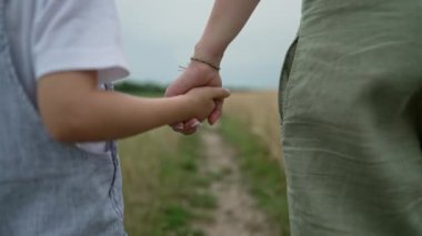 Anne ve Çocuk yürüyor, el ele tutuşuyorlar. Kırsal Peyzaj Yolu. Ekolojik Yaşam, Doğanın Dışında Şehir. Mutlu tanınmayan anne, aşk, özgürlük, gelecek, ev, kırsal, yeşil çocukluk, yüksek kalite 4k.