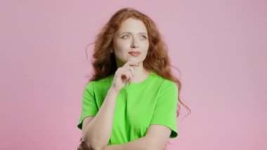 Mutlu kadının fikir üretme anı, pembe arka planı işaret ediyor. Akıllı bir bayan cevap veriyor ya da ne unuttuğunu hatırlıyor, hafıza konsepti. Yüksek kalite 4k