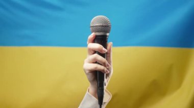 Kadın şarkıcı TV sunucusu mikrofonu tutuyor, Mike ya da Ukrayna bayrağını elinde tutan mikrofon. Haber, röportaj, basın toplantısı, müzik yarışması veya Ukrayna 'da müzik konseri. Yüksek kalite 4k görüntü