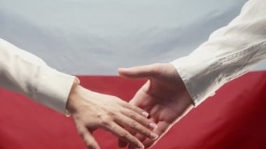 Kadın ve erkeğin elleri Polonya bayrağının arka planında uzanıyor. Polonya, anlaşma, işbirliği konsepti. Aşıklar, aile, güven, aşk ve mutluluk kavramı. Yüksek kalite 4k görüntü
