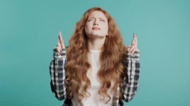 Mavi arka planda dua eden sevimli genç bir kadın. Hanımefendi birine arzularını tatmin etmesi için yalvarır, yardım eder, şans için dua eder. Yüksek kalite 4k