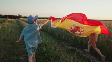 İspanyol taraftar çocuklar ulusal Espana bayrağıyla açık alanda kutlama yapıyorlar. İspanya ülkesi, futbol taraftarı, şampiyonluk konsepti.
