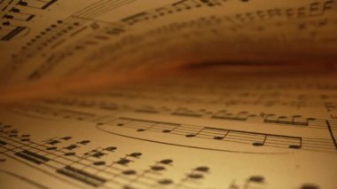 Kaydedilmiş ortaçağ müzik kitaplarının kaypak makro arkaplanı ve antik notalar. Eski klasik senfoninin dokusu, güzel melodi, hobi konsepti. Yüksek kalite 4k görüntü