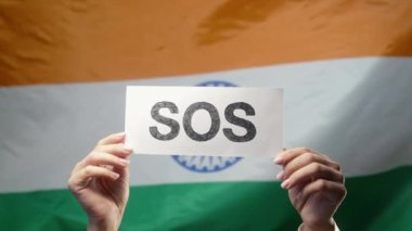 Soslu Kadın Eller, Alarm, Hindistan Bayrağı Arkaplanındaki Acil Durum Kartı. Yardım iste, Hindistan 'da çevre bakımı. Yüksek kalite 4k görüntü