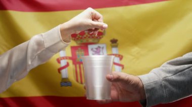 İspanyol Zengin Kadın, Espana bayrağında sadaka isteyen Evsiz Adam Plastik Kupasına Para Atıyor. Paylaşmak ve birbirimize yardım etmek. Yoksul hayat, işsizlik, yoksulluk sınırının altındaki insanlar. 4k görüntü