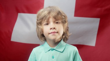 İsviçre Ulusal Bayrağı Altında Mutlu İsviçre Küçük Vatansever Çocuğu. Demokrasinin, bağımsızlığın, AB 'nin geleceğinin sembolü. afiş, çocuk günü, seçim, Avrupa, futbol. 