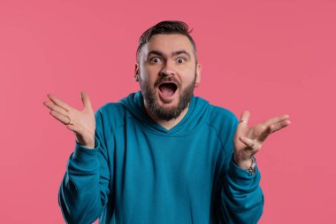 Beyaz, yakışıklı, şok olmuş adam sevindi. Çığlık attı. İlgi çekmeye çalışan etkileyici bir adam. Yaz indirimi kavramı, karlı bir teklif. Pembe arka planda heyecanlı bir mutluluk. Yüksek kalite