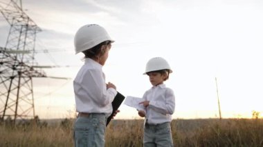 Anaokulu çocukları mühendis ya da kasklı yöneticiler. Elektrik endüstrisinde iş, gercekten zeki çocuklar elektrik voltaj kuleleri ile ilgili dokümanları okuyor. - Evet. Yüksek kalite 4k görüntü