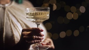 Tanımlanamayan bir kadın düğünü kutluyor. Şampanya içmek ya da Retro Style Glass 'dan şarap içmek. Yaz bahçesinde ışıklı bir parti. Yüksek kalite 4k görüntü