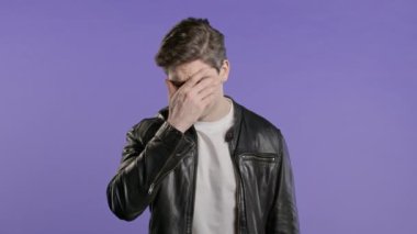 Endişeli adam facepalm jesti yapıyor, yüzünü ellerle kapatıyor, hayır, unuttum. Üzüntü, pişmanlık, drama, başarısızlık, mor arka planda sorunlar hisseden bir adam. Yüksek kalite 4k