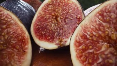 Kamera dilimlenmiş yarımlar, sağlıklı sulu incirler arasında hareket eder. Dolly Slider ekstrem makro. Mevsimlik meyve ayrıntıları, yakın çekim tohumları, Ficus carica dokusu. Yüksek kalite 4k görüntü