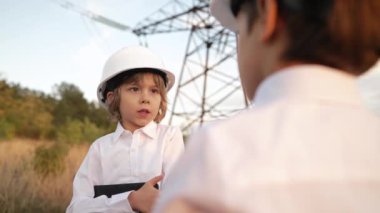Anaokulu çocukları mühendis ya da kasklı müdür. Elektrik endüstrisinde iş, gercekten zeki bir cocuk elektrik voltaj kuleleri ile ilgili dokümanlari okuyor. Yüksek kalite 4k