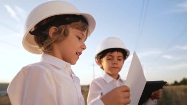 Anaokulu çocukları mühendis ya da kasklı müdür. Elektrik endüstrisinde iş, gercekten zeki bir cocuk elektrik voltaj kuleleri ile ilgili dokümanlari okuyor. Yüksek kalite 4k