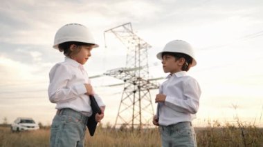Anaokulu çocukları mühendis ya da kasklı müdür. Elektrik endüstrisinde iş, gercekten zeki bir cocuk elektrik voltaj kuleleri ile ilgili dokümanlari okuyor. Yüksek kalite 4k