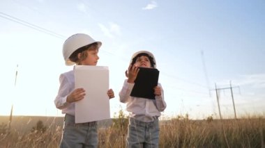 Anaokulu çocukları mühendis ya da kasklı müdür. Elektrik endüstrisinde iş, gercekten zeki bir cocuk elektrik voltaj kuleleri ile ilgili dokümanlari okuyor. Yüksek kalite 4k