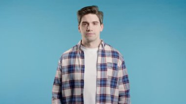 Dost canlısı bir adamın vesikalığı, kendine güvenen stil sahibi bir adamın mavi stüdyodaki portresi. Yüksek kalite 4k