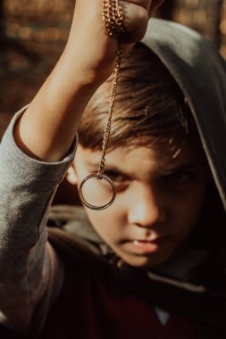 Sonbahar ormanlarında pelerin giyip altın yüzüğe hayran olan küçük kozcu hobbit çocuk. Fantezi yolculuğu, cadılar bayramı, kardeşlik kostümü. Yüksek kalite