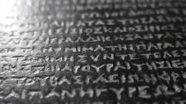 Rosetta Taşı, Mısır hiyerogliflerinin şifresini çözmek için üç yazıyla kazınmış antik bir taş. Makro yakın çekim. Müzede sergi. Eğitici, tarihi, kültürel içerik. 4k