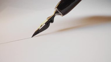 Antika Çeşme kalem ucu kağıt üzerinde pürüzsüz bir şekilde süzülerek mürekkep izi bırakıyor. Sanatsal görsel, çizim çizgisi, lüks kırtasiye konsepti. Yüksek kalite 4k görüntü