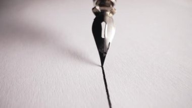 Parlak Metal Ucu ve Parlak Fıçıları olan Lüks Fıskiye Kalemi Macro. Beyaz desenli kağıt yüzeyine düz mürekkep satırı yazıyorum. Yüksek kalitede 4K görüntülerde zarif yazı. Klasik Araçlar.
