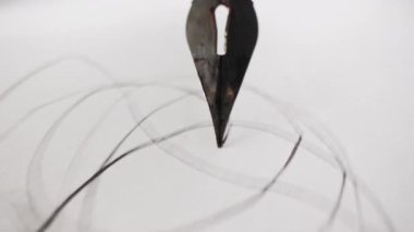 POV - Zarif Çeşme Kalemi 'nden Macro rastgele çizgiler ve işaretleri kağıda çiziyor. Mürekkep akışı, uç hareketi. El yazısı, kırtasiye, yaratıcılık konsepti. Yüksek kalite 4k görüntü