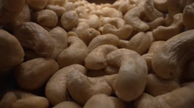 Organik kabuklu kaju fıstığı, yakın plan bebek manzaralı. Yüksek protein ve kalorili yiyecekler, ticari eklentiler. Vejetaryenler için lezzetli süper yiyecekler. Doğal doku şekilleri. Yüksek kalite 4k görüntü