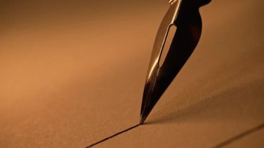Antika Çeşme kalem ucu kağıt üzerinde pürüzsüz bir şekilde süzülerek mürekkep izi bırakıyor. Sanatsal görsel, çizim çizgisi, lüks kırtasiye konsepti. Yüksek kalite 4k görüntü