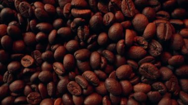 Makro Aromatik Kavrulmuş Kahve Fasulyesi. Doğal desenli yüzey. Zengin aroma, kafein konsepti. Sabah enerjisi. Taze organik tohumlar. Kolombiya Arap hasadı. Yüksek kalite 4k görüntü
