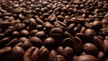Makro Aromatik Kavrulmuş Kahve Fasulyesi. Doğal desenli yüzey. Zengin aroma, kafein konsepti. Sabah enerjisi. Taze organik tohumlar. Brezilya Arap hasadı. Yüksek kalite 4k görüntü