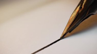 Parlak Metal Ucu ve Parlak Fıçıları olan Lüks Fıskiye Kalemi Macro. Beyaz desenli kağıt yüzeyine düz mürekkep satırı yazıyorum. Yüksek kalitede 4K görüntülerde zarif yazı. Klasik Araçlar.