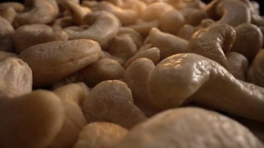 Organik kabuklu kaju fıstığı, yakın plan bebek manzaralı. Yüksek protein ve kalorili yiyecekler, ticari eklentiler. Vejetaryenler için lezzetli süper yiyecekler. Doğal doku şekilleri. Yüksek kalite 4k görüntü