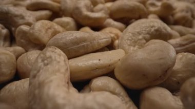 Organik kabuklu kaju fıstığı, yakın plan bebek manzaralı. Yüksek protein ve kalorili yiyecekler, ticari eklentiler. Vejetaryenler için lezzetli süper yiyecekler. Doğal doku şekilleri. Yüksek kalite 4k görüntü