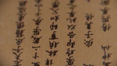 Geleneksel Çince karakterli eski el yazmasının stop-motion sekansı. Eskimiş kağıt, siyah mürekkep, karmaşık el yazısı. Tarih, kültür, eski bilgelik