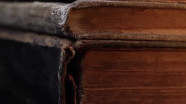 Eski kitap dikenlerinin yakın çekim makro görüntüsü, çatlak deri, yıpranmış sayfalar. Zengin dokular, solmuş bağlar. Tarih, antik edebiyat. Nostalji, bilgi, zaman kavramı. Yüksek kalite 4k