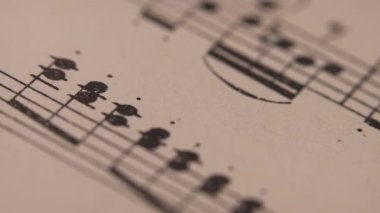 Mozart 'ın nota kağıtlı eski kitabının kaypak makro görüntüleri. Arşiv el yazmaları, piyano için klasik müzik notaları. Müzisyenler için eğitici semboller. Yüksek kalite 4k görüntü
