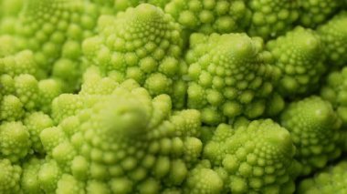 Sersemletici makro görüntüler taze Romanesco lahanası, karmaşık fraktal desenler, canlı yeşil renkler. Sağlıklı beslenme, organik gıda, doğal geometrik güzellik. Yüksek kalite 4k