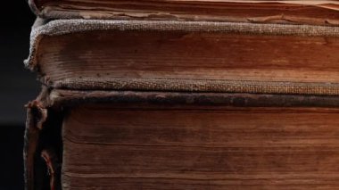 Eski kitap dikenlerinin yakın çekim makro görüntüsü, çatlak deri, yıpranmış sayfalar. Zengin dokular, solmuş bağlar. Tarih, antik edebiyat. Nostalji, bilgi, zaman kavramı. Yüksek kalite 4k