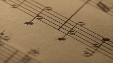Mozart 'ın nota kağıtlı eski kitabının kaypak makro görüntüleri. Arşiv el yazmaları, piyano için klasik müzik notaları. Müzisyenler için eğitici semboller. Yüksek kalite 4k görüntü