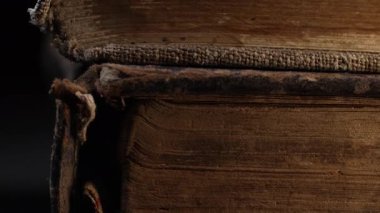 Eski kitap dikenlerinin yakın çekim makro görüntüsü, çatlak deri, yıpranmış sayfalar. Zengin dokular, solmuş bağlar. Tarih, antik edebiyat. Nostalji, bilgi, zaman kavramı. Yüksek kalite 4k