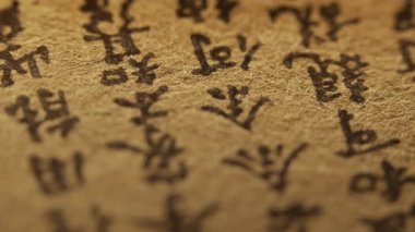 Geleneksel Çince karakterli eski el yazmasının makro görüntüsü. Eskimiş kağıt, siyah mürekkep, karmaşık el yazısı. Tarih, kültür, eski bilgelik