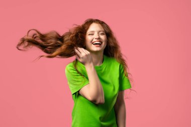 30 'lu yaşlarda eğlenen, en sevdiği müziği çalan, gülümseyen, pembe stüdyo arka planında dans eden komik bir kadın. Müzik, dans konsepti