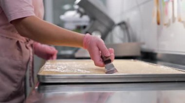 Mutfakta çalışan şekerci kadın. Badem hamuru pürüzsüz, ipeksi dokuya yayılıyor. Hassas hamur işleri - badem kurabiyeleri, tartlar, glütensiz fırınlar. 