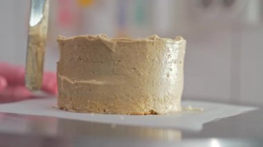 Pasta şefi pasta kenarlarını kremayla düzeltiyor. Şekerci spatulayla çalışıyor. Pasta dekorasyonu. Yüksek kalite 4k görüntü