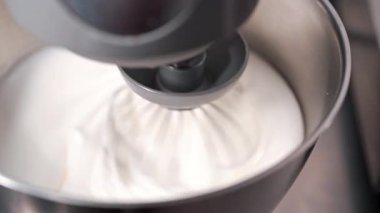 Yumurta beyazı yakın plan, sert tepeler için kırbaçlanmış. Pişirme, yemek tarifleri, sünger keki, kurabiyeler, tatlı. Pürüzsüz, havadar, parlak köpük dokusu. Yüksek kalite 4k görüntü