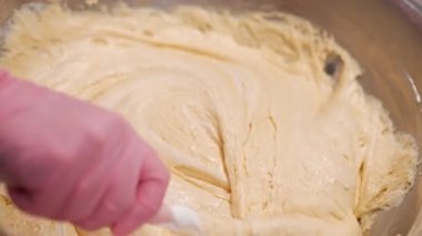 Pasta şefi hamuru karıştırır, sünger keki pişirir. Mutfakta çalışan pastacı kadın. Badem unu hamurunu pürüzsüz, ipeksi dokuya harmanlıyorum. Hassas hamur işleri - badem kurabiyeleri, tartlar, glütensiz fırınlar. 