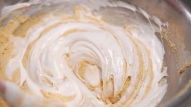 Pasta şefi hamuru karıştırır, sünger keki pişirir. Mutfakta çalışan pastacı kadın. Badem unu hamurunu pürüzsüz, ipeksi dokuya harmanlıyorum. Hassas hamur işleri - badem kurabiyeleri, tartlar, glütensiz fırınlar. 